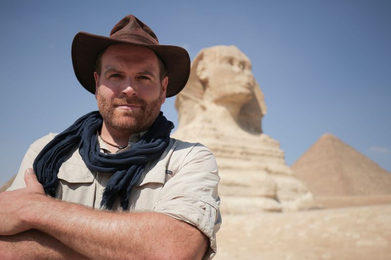 Josh Gates poses in front of the Great Sphinx in Egypt on his series "Expedition Unknown."