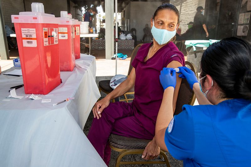 Marianne Lofton receives a first dose of the COVID-19 vaccine during the CSUSB Nursing Street Medicine Program's mobile vaccine clinic outside the Well in the Desert in Palm Springs, Calif., on May 7, 2021.