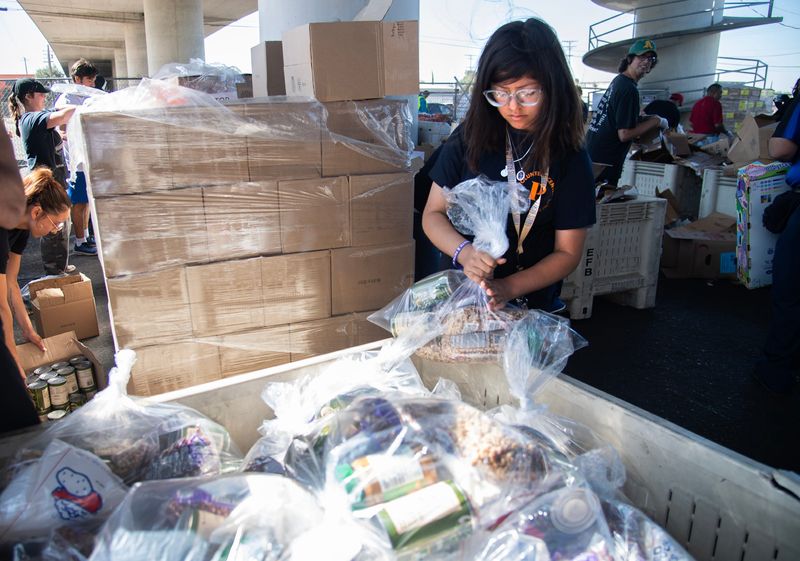 University of the Pacific student Itzel Mendez fills a bag with non-perishable goods while volunteering at the Stockton/San Joaquin Emergency Food Bank in Stockton on Aug. 22, 2024. Mendez was one of many students, staff and alumni who participated in the university’s Day of Service where students volunteer to do beautification of and/or support critical projects for community-based organizations and the City of Stockton.