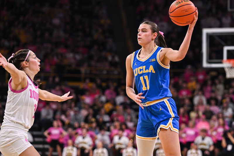 Feb 23, 2025; Iowa City, Iowa, USA; UCLA Bruins guard Gabriela Jaquez (11) controls the ball as Iowa Hawkeyes guard Taylor McCabe (2) looks on during the second quarter at Carver-Hawkeye Arena. Mandatory Credit: Jeffrey Becker-Imagn Images