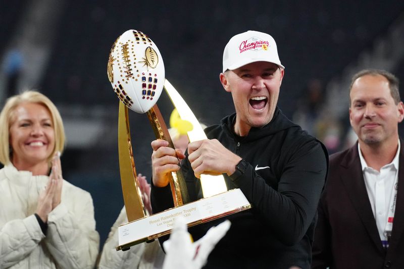 Dec 27, 2024; Las Vegas, NV, USA; Southern California Trojans head coach Lincoln Riley holds the championship trophy after the game against the Texas A&M Aggies at Allegiant Stadium. Mandatory Credit: Kirby Lee-Imagn Images