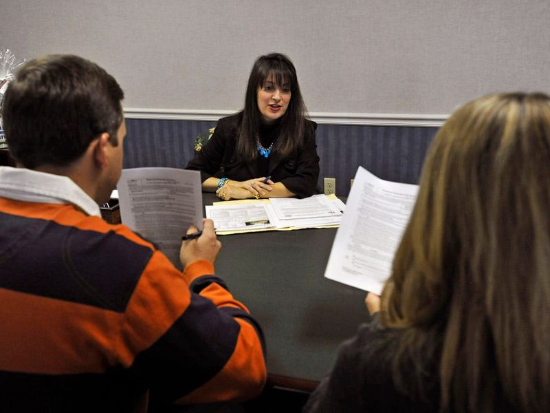 WILL DICKEY/The Times-UnionRealtor Debbie Shagnea (center) talks with home buyers Brian and Emily Steffes during a closing on their home Friday. Once a stay-at-home mom, she has now found success and great results selling real estate.