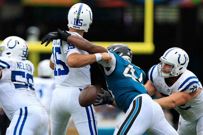 Indianapolis Colts quarterback Joe Flacco (15) fumbles the ball knocked loose by Jacksonville Jaguars defensive end Travon Walker (44) as Indianapolis Colts offensive tackle Braden Smith (72) defends during the second quarter of an NFL football matchup Sunday, Oct. 6, 2024 at EverBank Stadium in Jacksonville, Fla. The Jaguars edged the Colts on a field goal 37-34. [Corey Perrine/Florida Times-Union]