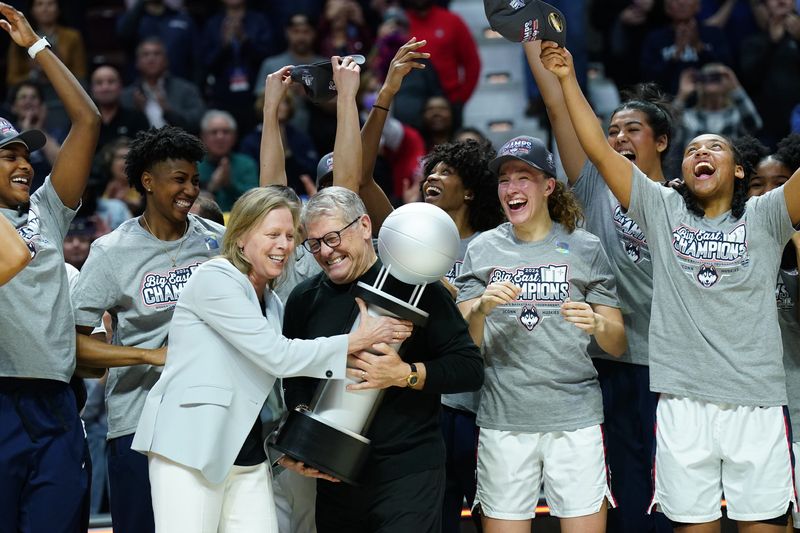UConn Huskies head coach Geno Auriemma is handed the Big East Conference Championship trophy after defeating the Georgetown Hoyas at Mohegan Sun Arena on Mar 11, 2024.