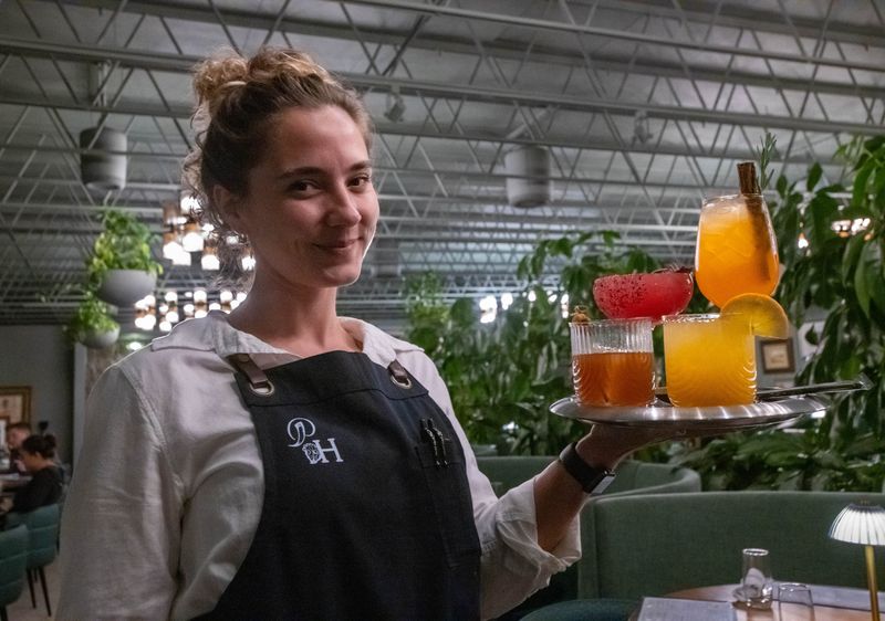 Server Meg Conto carries a tray of cocktails in the Horn Room at Restaurant of Year - Pearl & Horn in Pensacola on Thursday, Nov. 21, 2024.