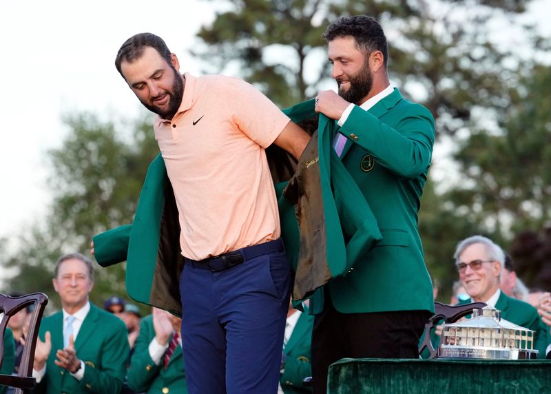 Apr 14, 2024; Augusta, Georgia, USA; 2023 Masters champion Jon Rahm places the green jacket on 2024 Masters champion Scottie Scheffler during the green jacket ceremony following the final round of the Masters Tournament. Mandatory Credit: Rob Schumacher-USA TODAY Network