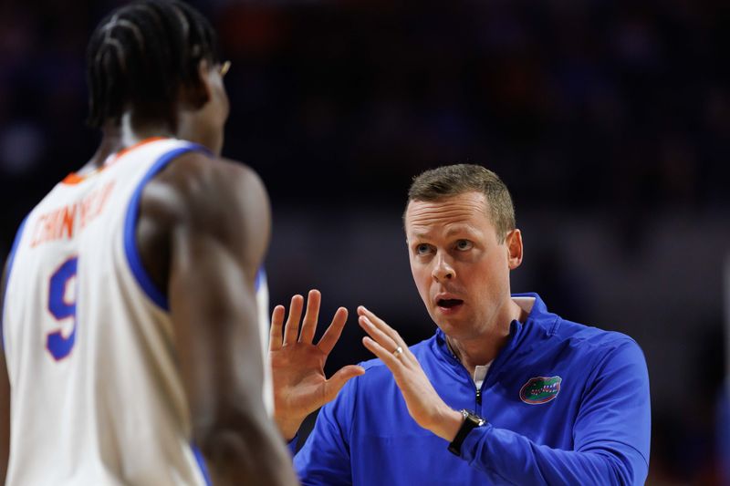 Feb 18, 2025; Gainesville, Florida, USA; Florida Gators assistant coach Kevin Hovde talks with Florida Gators center Rueben Chinyelu (9) after a timeout against the Oklahoma Sooners during the first half at Exactech Arena at the Stephen C. O'Connell Center. Mandatory Credit: Matt Pendleton-Imagn Images