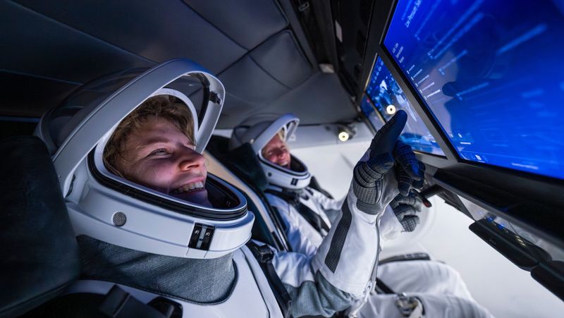 Rogge (mission pilot) and Mikkelsen (vehicle commander) pose while training in the SpaceX Dragon simulator.