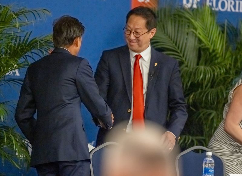 Santa Ono, current present of the University of Michigan and the sole finalist for the same position at the University of Florida, greets Rahul Patel, chair of UF's Presidential Search Committee and vice chair of the university's board of trustees, on May 6 at Emerson Alumni Hall in Gainesville.