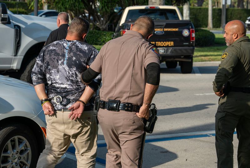 Border patrol agents, in cooperation with Palm Beach police and the Florida Highway Patrol, arrest one of three men in front of the skinny dip store on Jimmy Buffett Memorial Highway (Royal Poinciana Way) around 8:20 am Friday May 9, 2025.