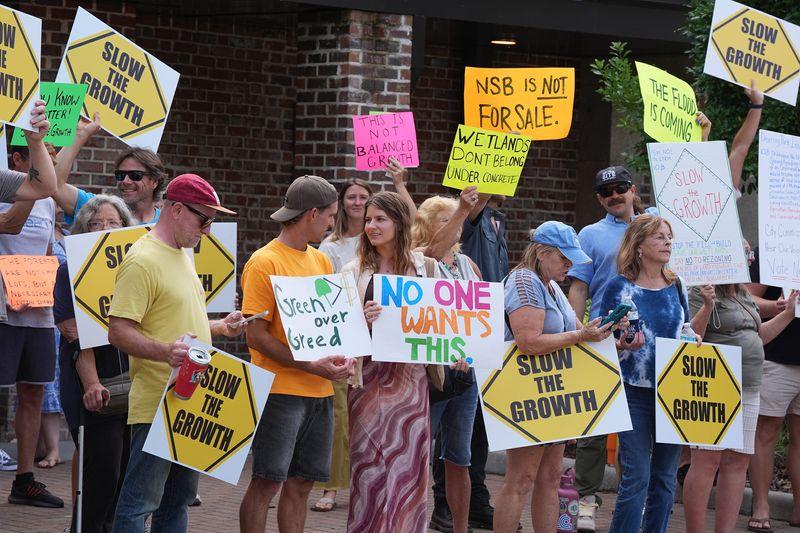 Protesters line up outside New Smyrna Beach City Hall to protest the 1,618-acre Deering Park Innovation Center project, Tuesday, May 13, 2025.
