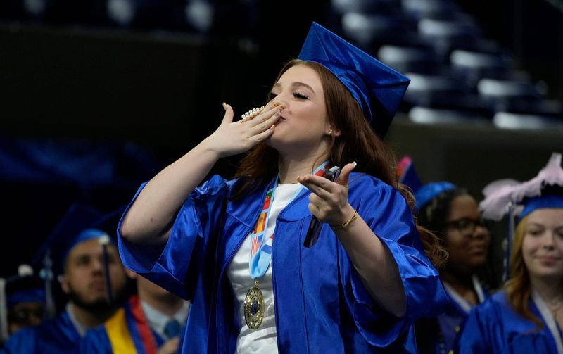 Melany Perez, blows kisses to the crowd while on her way to accepting her diploma. Gateway Charter High School Class of 2025 graduated May 13, 2025, at Alico Arena at Florida Gulf Coast University in Estero. The 137 seniors at the high school are among the first to graduate as the 2025 season kicks off.