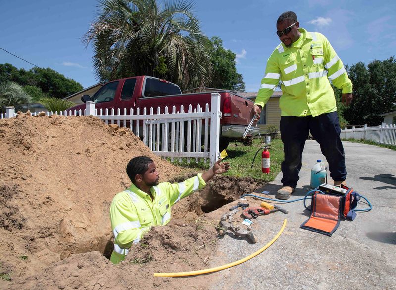 Pensacola Energy employees Paul Bush and Sabron Ailkens work on upgrading the gas service in the Rolling Hills neighborhood on May 15, 2025.