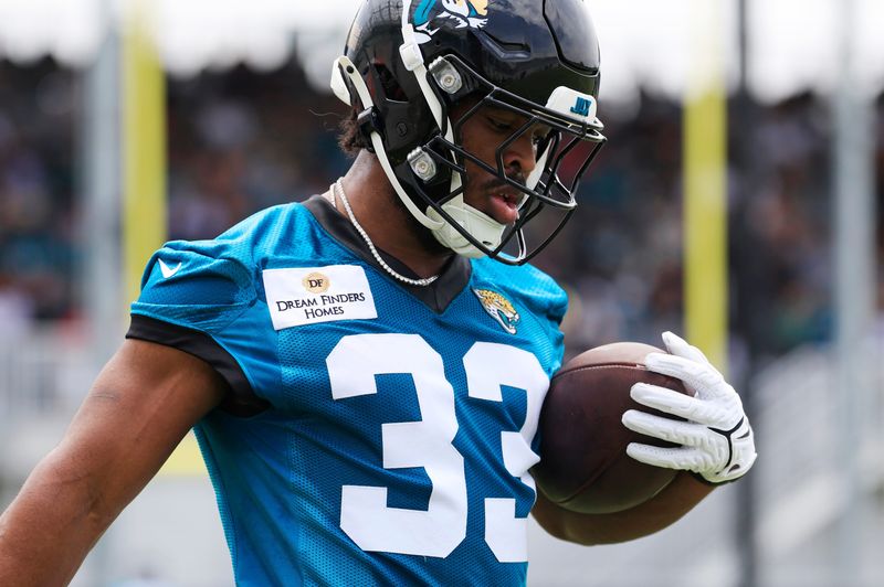 Jacksonville Jaguars running back Bhayshul Tuten (33) runs the ball during a rookie minicamp at Miller Electric Center Saturday, May 10, 2025 in Jacksonville, Fla. [Corey Perrine/Florida Times-Union]