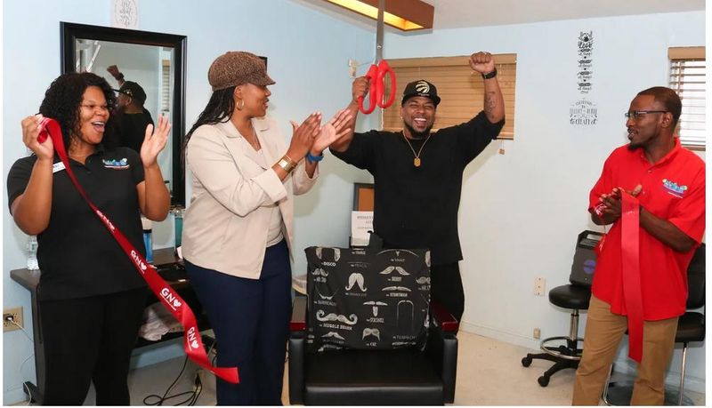 Michael P. Powers, with arms uplifted, benefited from a Gainesville Housing Authority job training program that led to him starting his own barbershop business.

Gainesville Sun file photo by Allison Durham