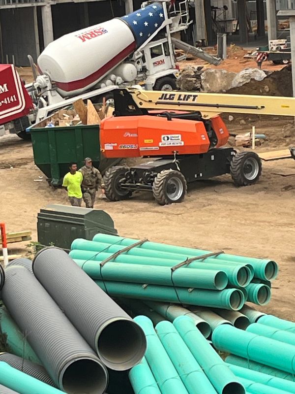 ICE agents talking to the construction workers arrested and more construction workers pulled and zipped tied to one another during a raid in CollegeTown on Thursday, May 29, 2025.