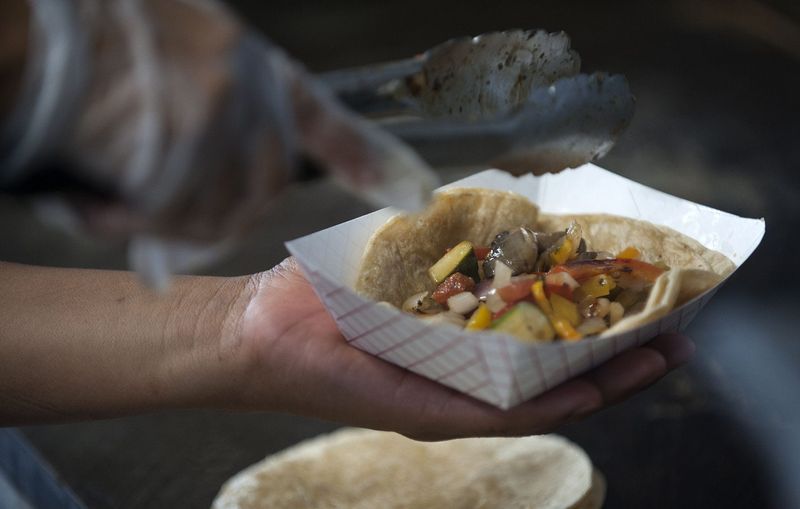 Pilar Gonzales, owner of Pili’s Party Tacos, fills a taco for a customer in 2017.