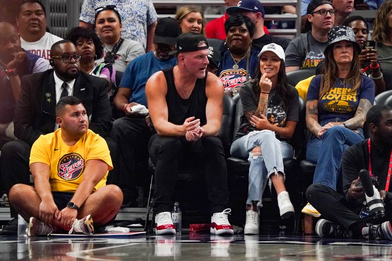 Retired Indianapolis Colts player American sports analyst Pat McAfee and family attend 
a game between the Indiana Fever and the Chicago Sky on Saturday, June 1, 2024, at Grainbridge Fieldhouse in Indianapolis.