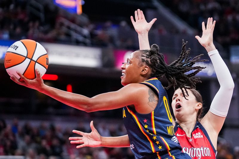 Indiana Fever Kelsey Mitchell (0) goes up for a basket against Washington Mystics Jade Melbourne (5) on Saturday, May 3, 2025, during a preseason game between the Indiana Fever and the Washington Mystics at Gainbridge Fieldhouse in Indianapolis. The Indiana Fever defeated the Washington Mystics in overtime, 79-74.