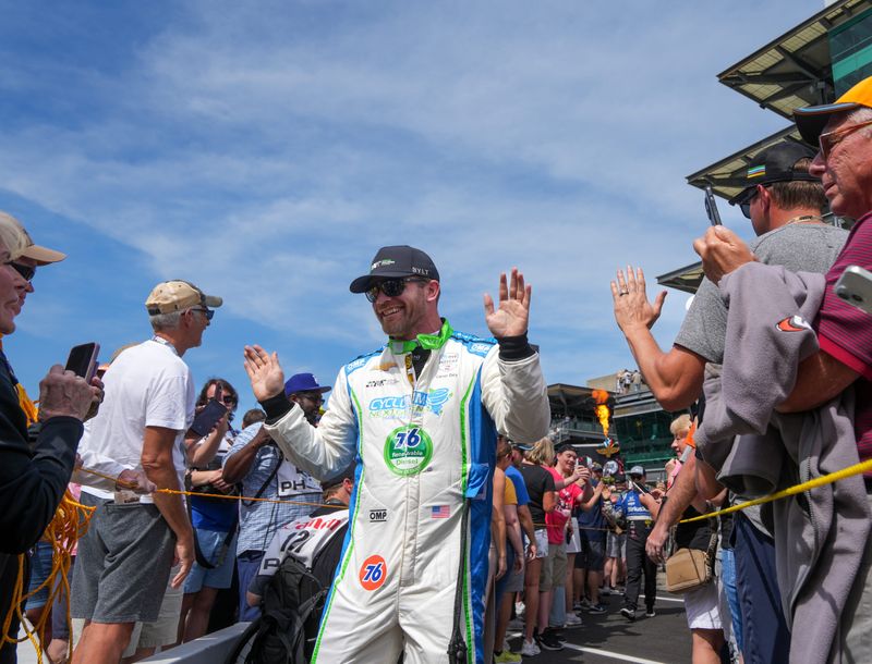 Juncos Hollinger Racing driver Conor Daly (76) of United States high fives fans during the drivers parade on Saturday afternoon, May 10, 2025, just prior to the Sonsio Grand Prix at Indianapolis Motor Speedway.