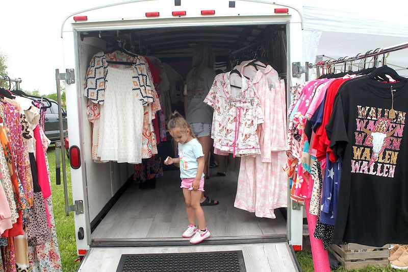 Rylee Crane stands at the entrance of Sassy Kate Boutique while her mother shops the Spring 2025 Sunflower Market at Lambrecht Farm on Saturday, May 10, 2025.