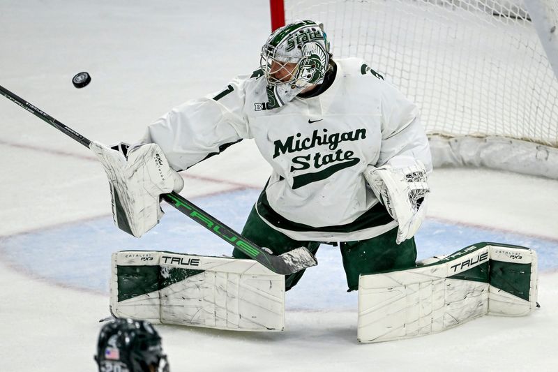 Michigan State's Trey Augustine deflects a Minnesota shot during overtime on Saturday, Jan. 25, 2025, at Munn Arena in East Lansing.