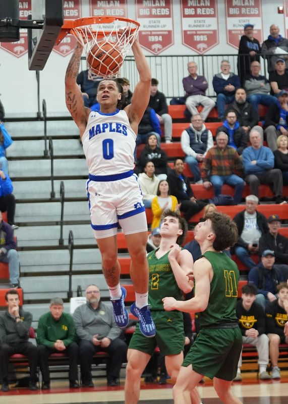 Adrian's Stevie Elam dunks during the MHSAA Division 2 regional semifinal at Milan against Flat Rock.
