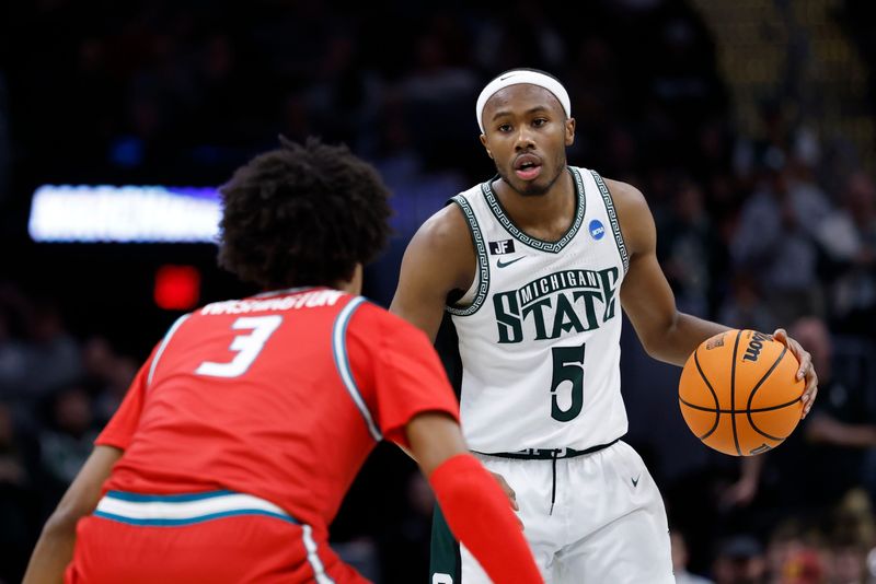 Mar 23, 2025; Cleveland, OH, USA; Michigan State Spartans guard Tre Holloman (5) dribbles defended by New Mexico Lobos guard Tru Washington (3) in the first half during the NCAA Tournament Second Round at Rocket Arena. Mandatory Credit: Rick Osentoski-Imagn Images