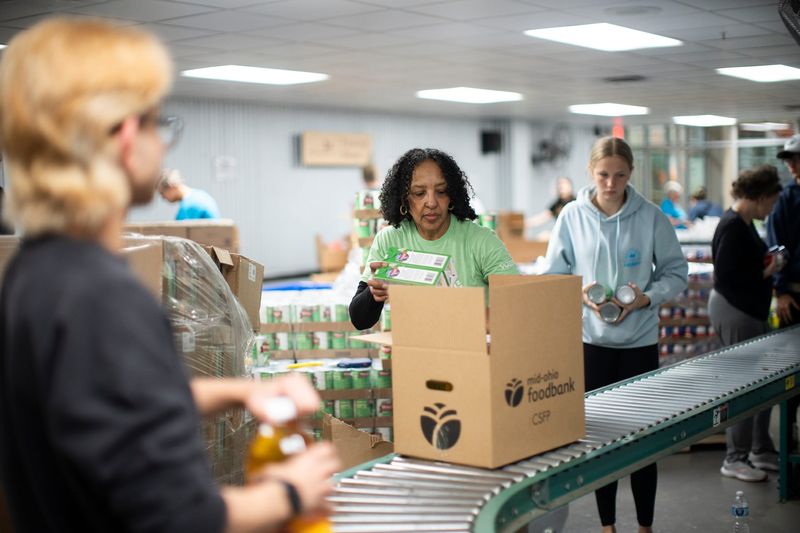 Volunteers pack boxes for seniors at the Mid-Ohio Food Collective on Thursday, Mar 27, 2025 in Grove City, Ohio. A new federal cut will eliminate $1.4 million worth of meat, dairy and eggs from the food bank.
