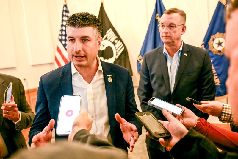 U.S. Rep Tom Barrett, R-Charlotte, left, speaks to media after visiting with veterans on Monday, March 31, 2025, at the American Legion Post 141 in Howell. At right, VA Secretary Doug Collins looks on.