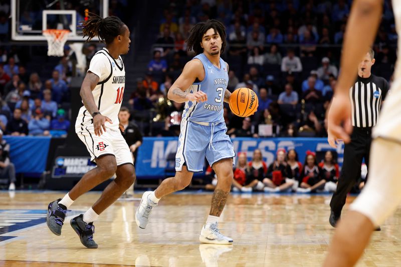 Mar 18, 2025; Dayton, OH, USA; North Carolina Tar Heels guard Elliot Cadeau (3) dribbles the ball defend by San Diego State Aztecs guard BJ Davis (10) in the second half at UD Arena. Mandatory Credit: Rick Osentoski-Imagn Images