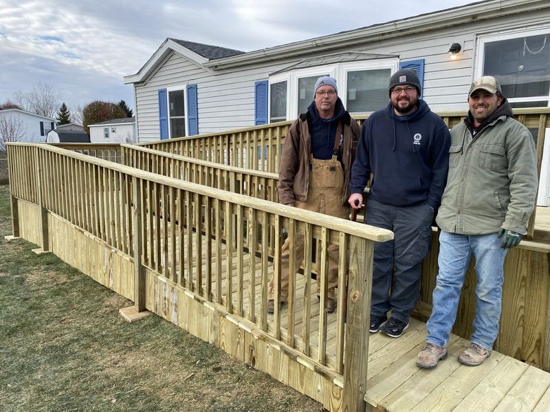 Rob Teznar (from left), Garrett Matt and Don Beard from IBEW Local 8 stand on the ramp they and others built for their union brother in need.