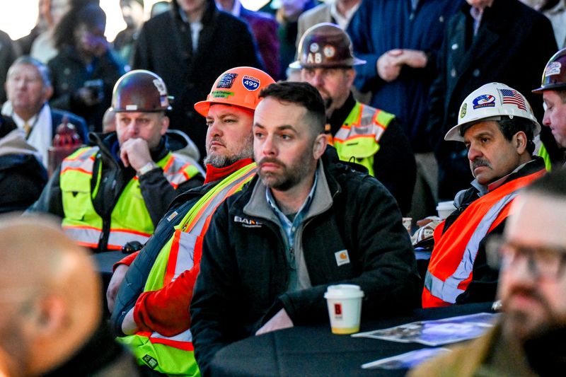 Union trades workers look on during a groundbreaking ceremony for New Vision Lansing's Tower on Grand on Monday, April 7, 2025, in downtown Lansing.
