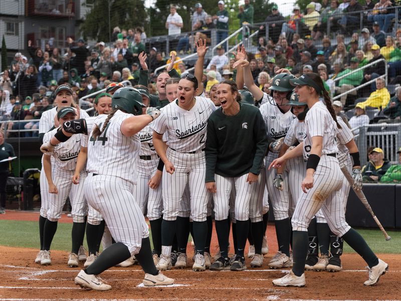 Michigan State teammates welcome Kaelin Cash after she hit solo home run against Oregon at Jane Sanders Stadium.