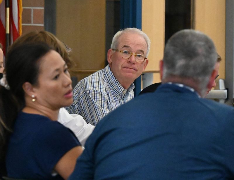 Harbor Springs Board of Education president Paul Fairbairn (middle) talks with fellow board members during a special meeting called for Thursday, May 15 regarding the recent decisions to not renew the contracts of varsity basketball coaches John and Amy Flynn at Harbor Springs High School.