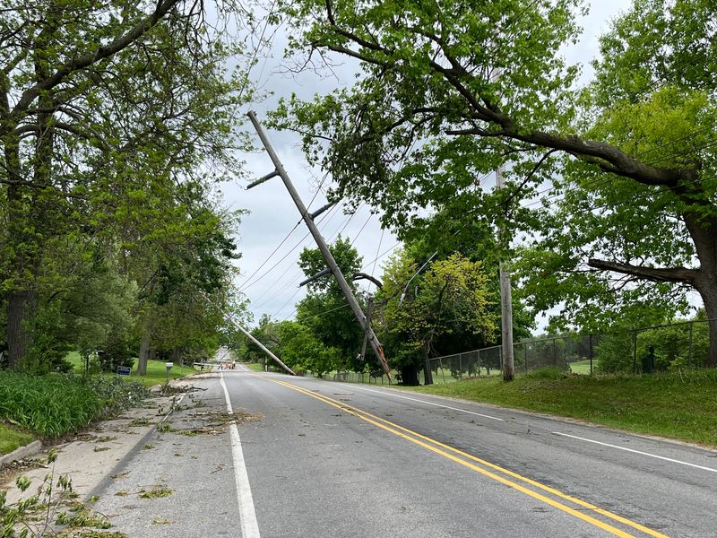 A transmission pole suspended by electrical wires over Wood Street in Lansing seen on Saturday, May 17, 2025, following a tornado and storm that hit the area on May 15.