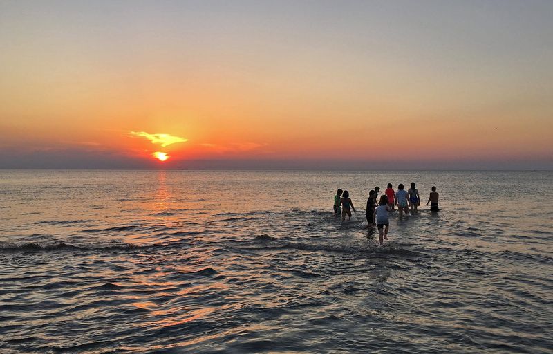 People go for a swim as they watch the sun set on Lake Michigan in Michigan City, Indiana in June of 2016.