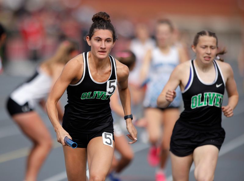 Olivet's Celina Sinclair, left, takes the baton on the anchor leg from Cassie Coleman en route to winning the 4x200-meter relay
during MHSAA Division 3 Track and Field finals, Saturday, May 31, 2025, at Kent City High School.