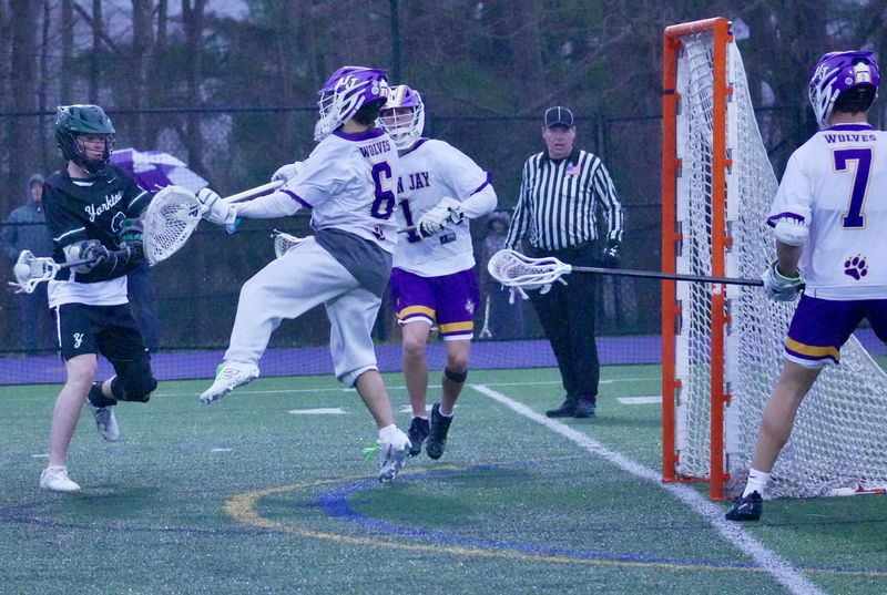 John Jay goalie Blake O'Callaghan meets Yorktown's Brady Sheridan at the point of attack during the Huskers' 6-2 win on Saturday, April 5, 2025 at John Jay High School in Cross River, N.Y.