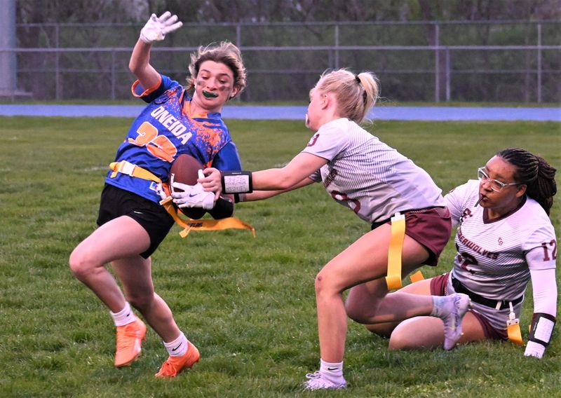 Oneida ball-carrier Taydem Marsh works her way around Sherburne-Earlville tackler Aubrey Davis (right) Thursday.