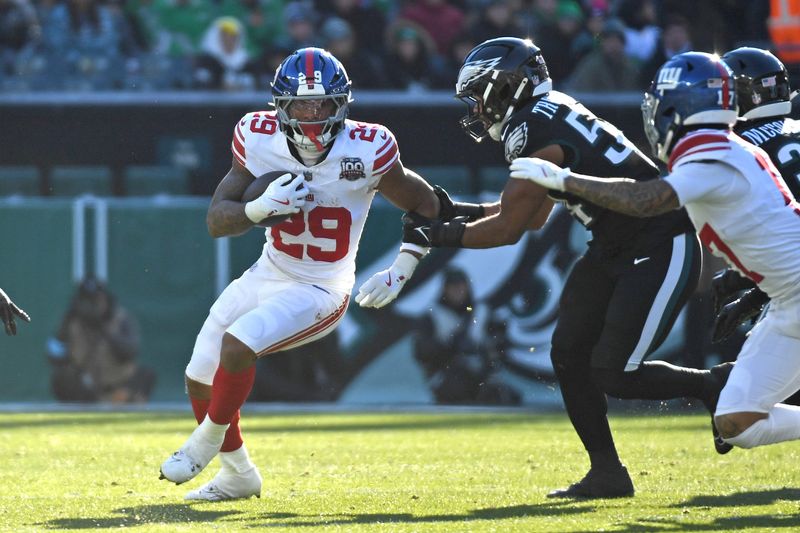Jan 5, 2025; Philadelphia, Pennsylvania, USA; New York Giants running back Tyrone Tracy Jr. (29) runs past Philadelphia Eagles linebacker Jeremiah Trotter Jr. (54) during the second quarter at Lincoln Financial Field. Mandatory Credit: Eric Hartline-Imagn Images