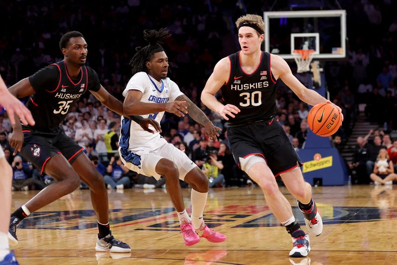 FILE PHOTO: Mar 14, 2025; New York, NY, USA; Connecticut Huskies forward Liam McNeeley (30) controls the ball against Creighton Bluejays guard Jamiya Neal (5) during the first half at Madison Square Garden. Mandatory Credit: Brad Penner-Imagn Images/File Photo