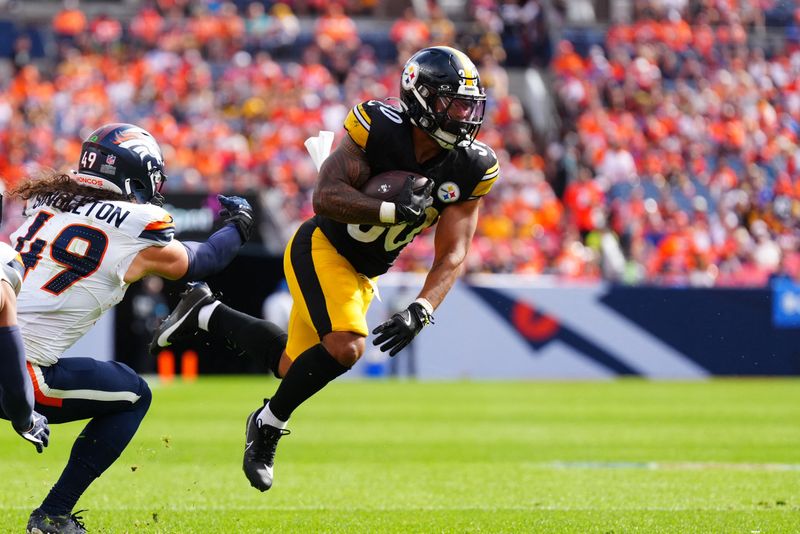 FILE PHOTO: Sep 15, 2024; Denver, Colorado, USA; Pittsburgh Steelers running back Jaylen Warren (30) catches the ball past Denver Broncos linebacker Alex Singleton (49) in the second quarter at Empower Field at Mile High. Mandatory Credit: Ron Chenoy-Imagn Images/File Photo