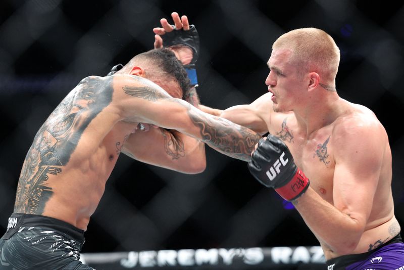 Apr 26, 2025; Kansas City, Missouri, UNITED STATES; Ian Machado Garry (red gloves) fights Carlos Prates (blue gloves) during UFC Fight Night at T-Mobile Center. Mandatory Credit: William Purnell-Imagn Images