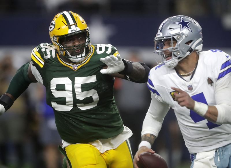 FILE PHOTO: Jan 14, 2024; Arlington, Texas, USA; Green Bay Packers defensive tackle Devonte Wyatt (95) rushes Dallas Cowboys quarterback Dak Prescott (4) during the fourth quarter in a 2024 NFC wild card game at AT&T Stadium. Mandatory Credit: Wm. Glasheen-USA TODAY Sports/File Photo