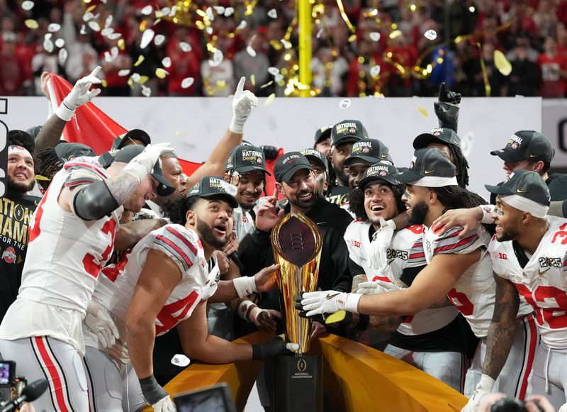 FILE PHOTO: Jan 20, 2025; Atlanta, GA, USA; Ohio State Buckeyes head coach Ryan Day and his team celebrate with the CFP National Championship trophy after defeating the Notre Dame Fighting Irish in the CFP National Championship college football game at Mercedes-Benz Stadium. Mandatory Credit: Kirby Lee-Imagn Images/File Photo