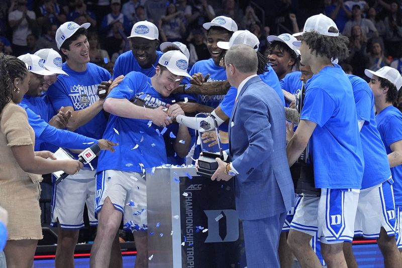 FILE PHOTO: Mar 15, 2025; Charlotte, NC, USA; Duke Blue Devils guard Kon Knueppel (7) celebrates with teammates after winning the most valuable player award for the 2025 ACC Conference Tournament after the championship game at Spectrum Center. Mandatory Credit: Jim Dedmon-Imagn Images/File Photo