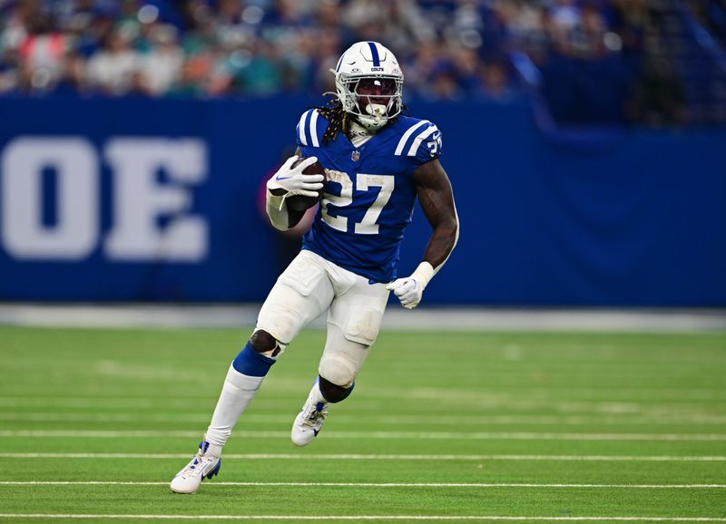 Oct 20, 2024; Indianapolis, Indiana, USA; Indianapolis Colts running back Trey Sermon (27) runs the ball during the second half against the Miami Dolphins at Lucas Oil Stadium. Mandatory Credit: Marc Lebryk-Imagn Images