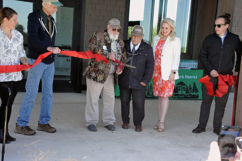 Andy McClure cuts the ribbon to officially open the Davy McClure Outdoor Eductation Center as Mary Meixnel, Thomas Kruse, Robert DeSanto, Melanie Miller and Erc Scnneider look on.