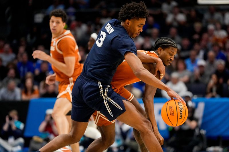 Xavier's Dailyn Swain, left, steals the ball from Texas guard Tramon Mark during the Musketeers' 86-80 win over Texas in a First Four game March 19 in Dayton, Ohio. Swain, a versatile 6-foot-8 wing, committed to Texas on Tuesday, according to multiple reports. He becomes the first player to pledge to Texas in the portal since the Longhorns hired former Xavier coach Sean Miller last week.